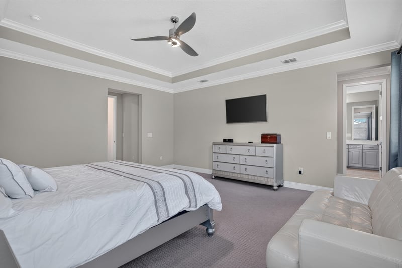 Primary bedroom with dresser and windows at 22 Azura Point