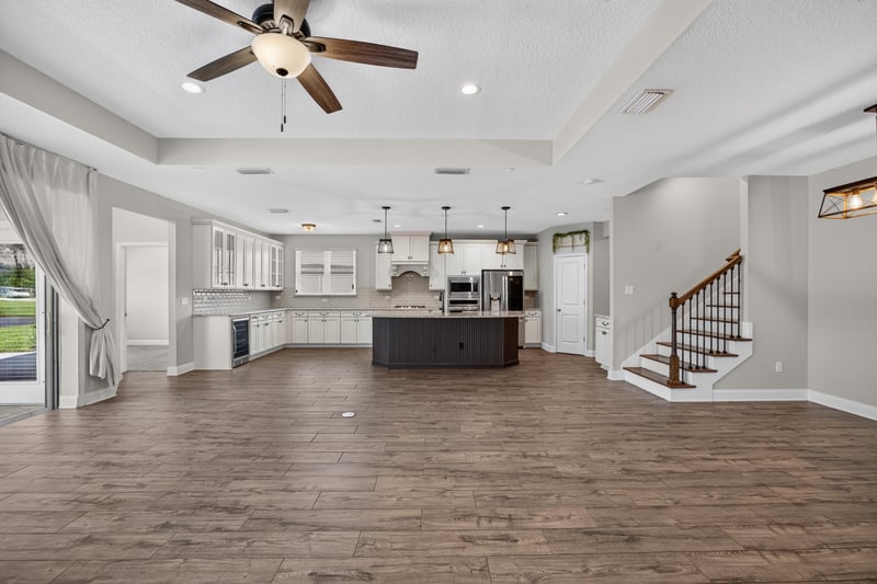 Open kitchen and living area with wood floors and staircase at 53 Lumen Ct, St. Augustine, FL 32095