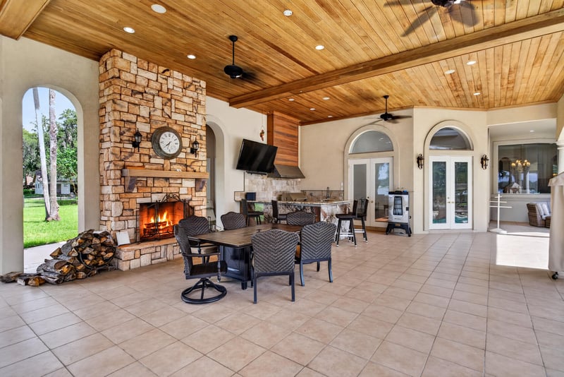 Covered patio with stone fireplace overlooking the pool at 344 Broward Rd, Jacksonville, FL