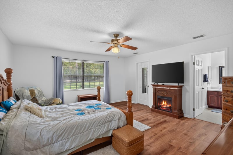 Bedroom with fireplace and television at 2435 Range Line Rd, Middleburg, FL
