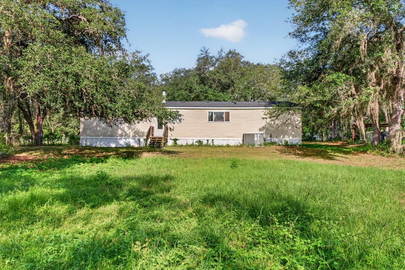 Side yard view with home and open lawn at 3215 Robin Ln, Middleburg, FL