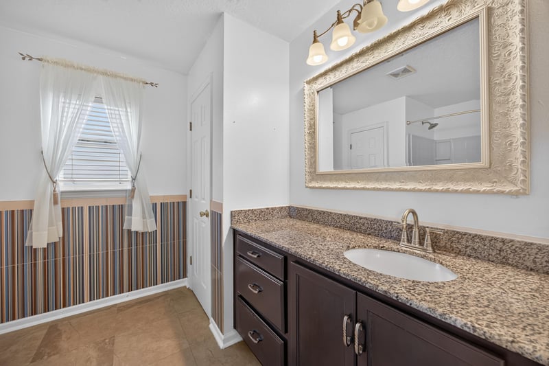Primary bathroom vanity with framed mirror at 2282 Justin Lake Dr, Jacksonville, FL