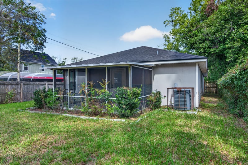 Back exterior with screened porch and AC unit at 1002 Ingleside Ave, Jacksonville, FL 32205