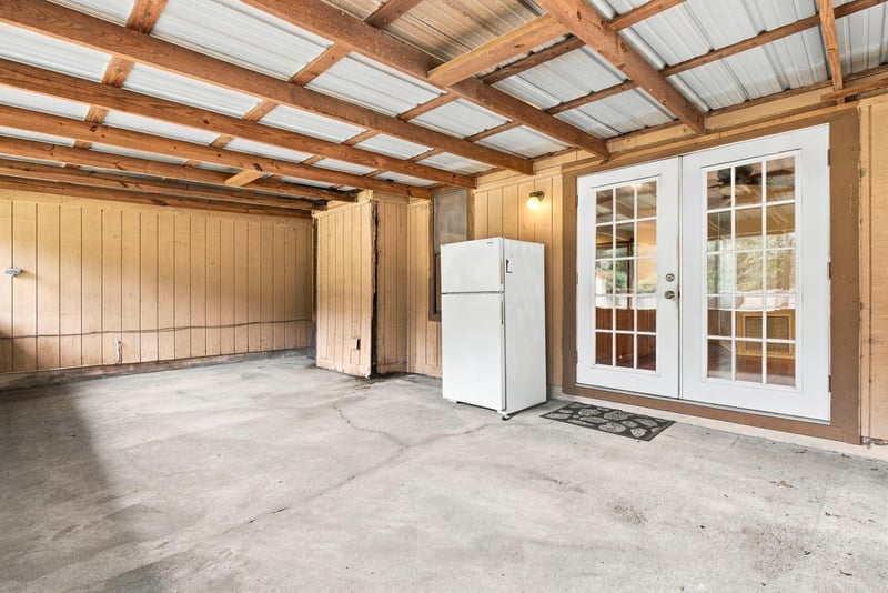 Garage interior with white refrigerator and French doors at 2915 Trenton Ct, Orange Park, FL
