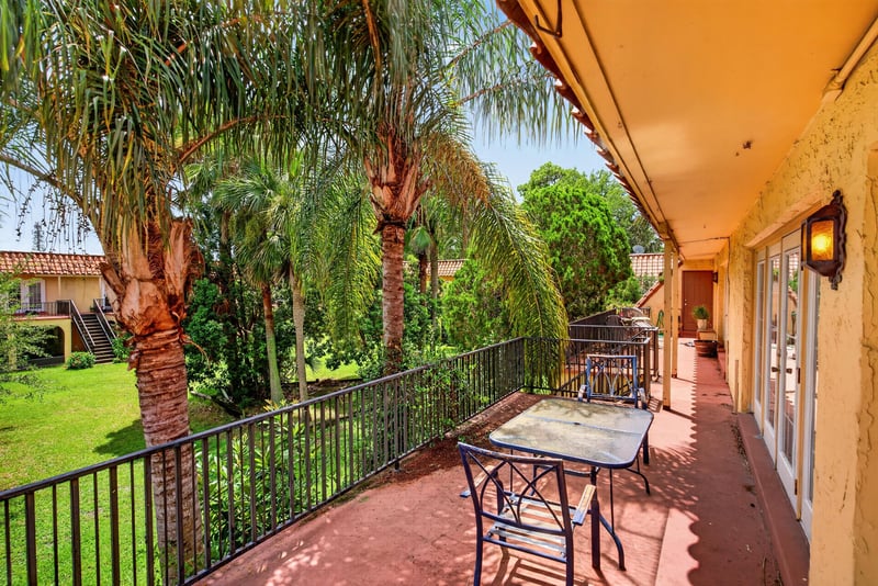 Covered walkway with patio table and palms at 3866 Campenero Ct unit 6, Jacksonville, FL 32217