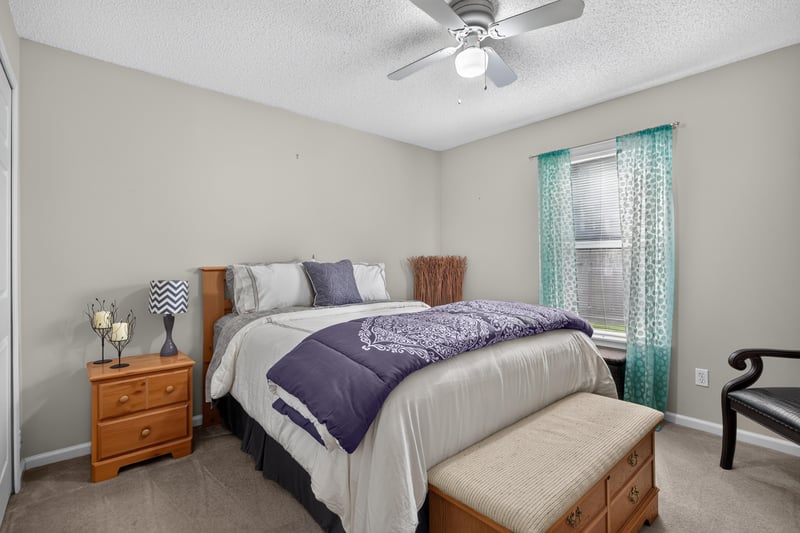 Bedroom with purple bedding and wood furniture at 3067 Wavering Ln, Middleburg, FL 32068