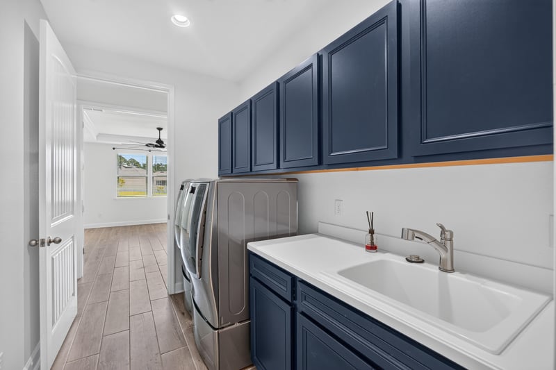 Laundry room with navy cabinets and sink at 855 Flach Dr, St. Johns, FL