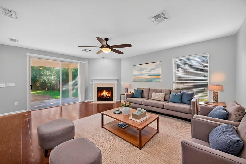 Family room with fireplace, staged sofa and ottoman at 470 Sparrow Branch Cir, Jacksonville, FL 32259