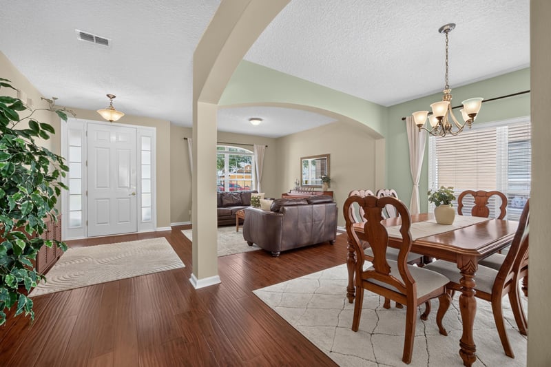 Open living and dining area with columns and wood floors at 3660 Middlebrook Dr, Orange Park, FL 32065