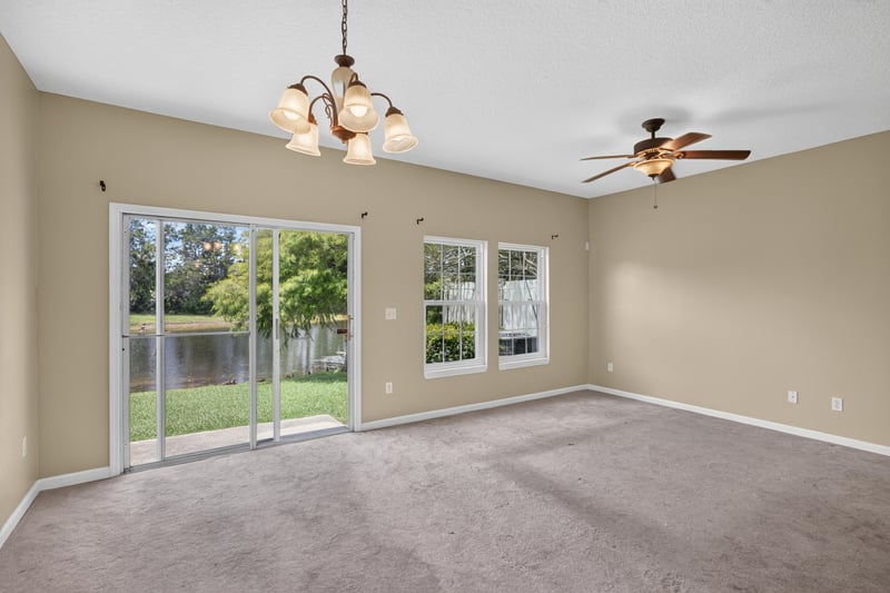 Living room with ceiling fan and sliding glass door to yard at 1572 Biscayne Bay Dr, Jacksonville, FL 32218