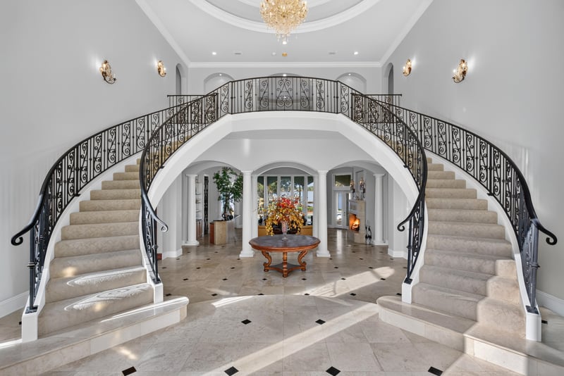 Grand foyer with dual curved staircases and chandelier at 344 Broward Rd, Jacksonville, FL