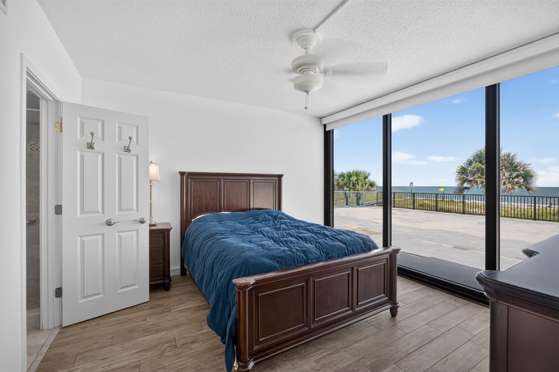 Bedroom with bed and ocean view through sliders at 601 1st St S, Jacksonville Beach