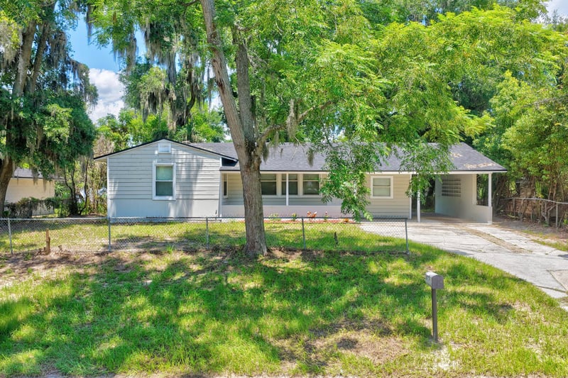 Front exterior with shaded yard and driveway at 855 Cornwallis Dr, Jacksonville, FL