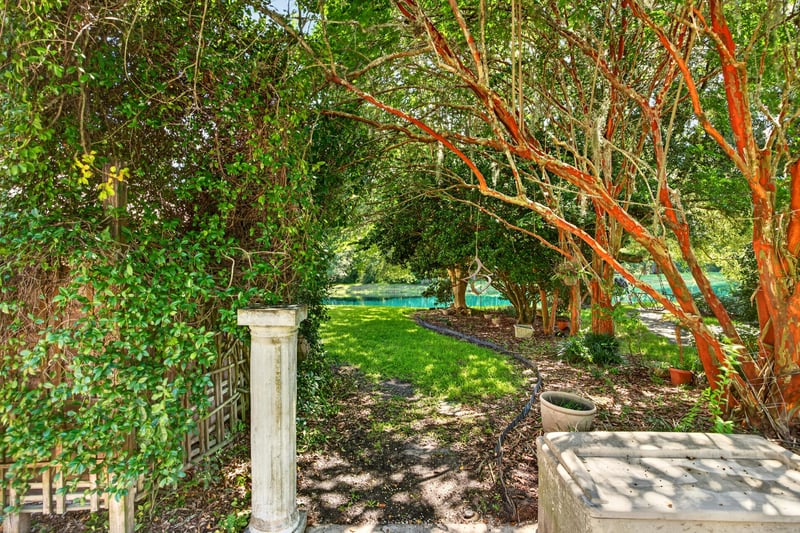 Side yard garden path with trees at 11675 Magnolia Estates Rd, Jacksonville, FL 32223