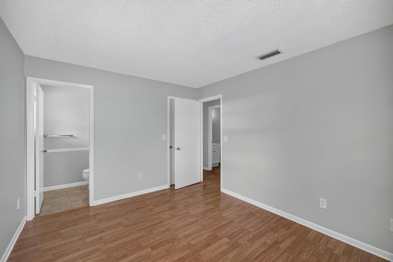 Hallway with wood laminate floor leading to two doors at 328 Palos Ct, St. Augustine, FL