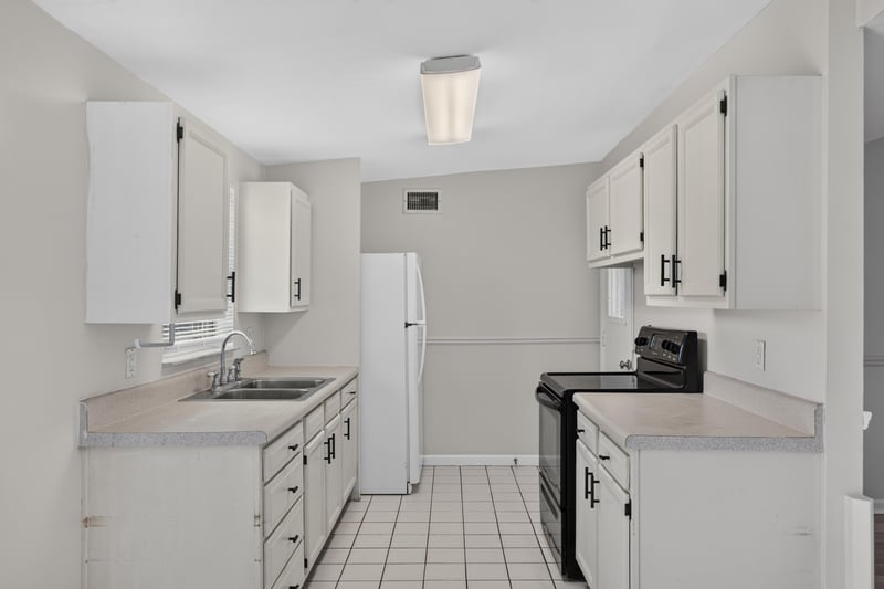 Kitchen with white cabinets and tile floor at 87 Saratoga Cir S, Atlantic Beach, FL