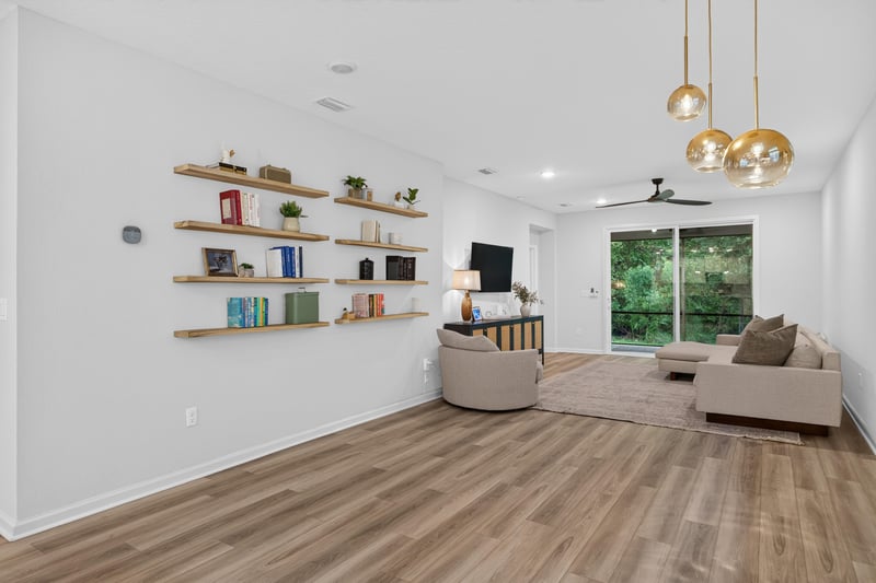 Open living area with floating shelves and sectional sofa at 93 Lochloosa Ct, St. Johns, FL 32259