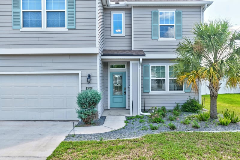 Front exterior with garage door and landscaped entry at 2580 Cold Stream Ln, Green Cove Springs, FL 32043