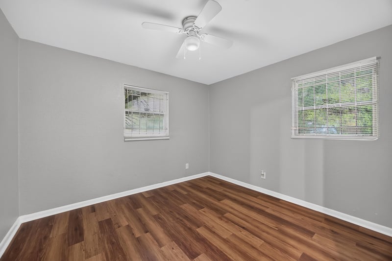 Empty bedroom with wood-look flooring and windows at 4030 Leonard Cir W, Jacksonville, FL 32209