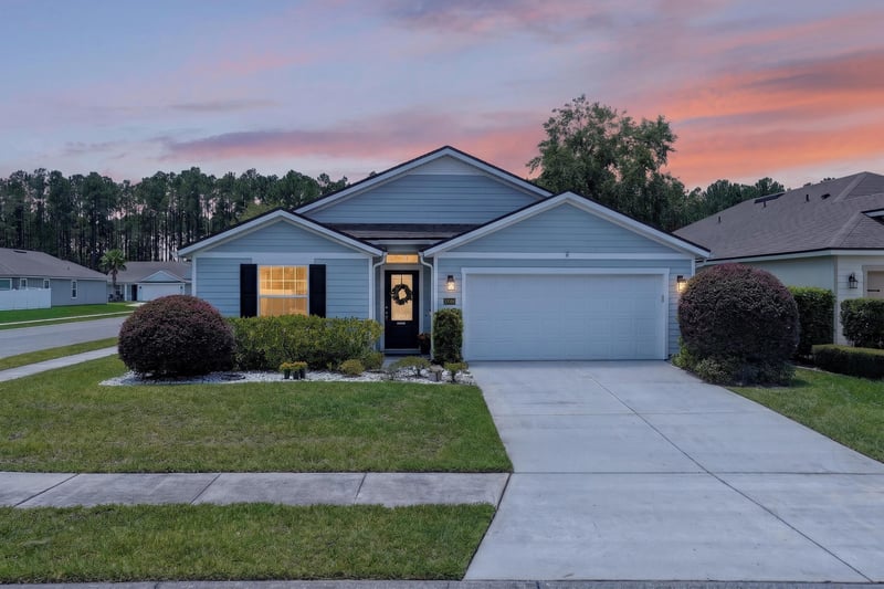 Day-to-dusk front exterior with covered entry and manicured lawn at 10066 Andean Fox Dr, Jacksonville, FL 32222