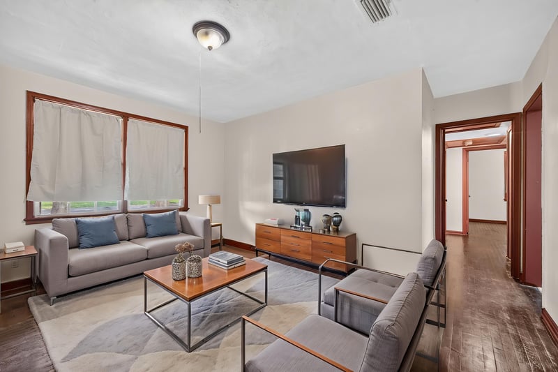 Living room staged with gray sofa and wood floors at 2132 Allandale Cir W, Jacksonville, FL