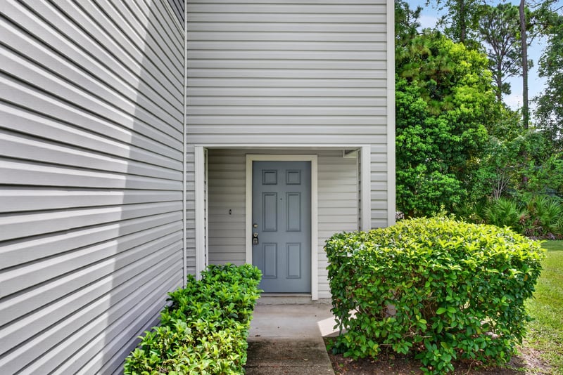 Front door with blue paint and foundation planting at 12359 Mangrove Forest Ct, Jacksonville, FL 32218