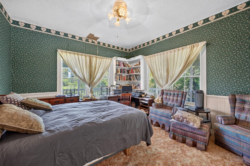 Bedroom with green wallpaper and seating area at 1173 US-17, Satsuma, FL 32189