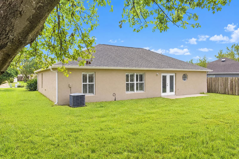 Rear exterior with patio doors and lawn at 11197 Illford Dr
