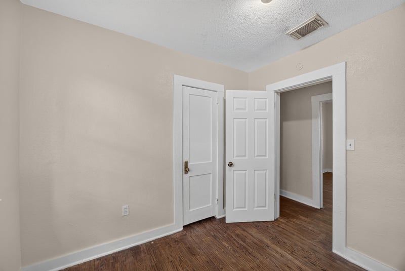 Hallway with multiple doors and wood floors at 1473 State St W, Jacksonville, FL 32209