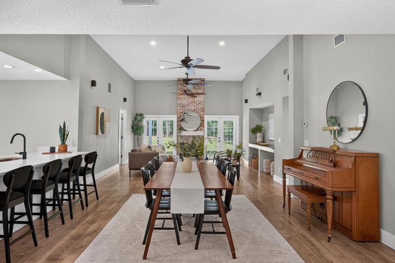 Open kitchen and dining area with piano and vaulted ceiling at 1161 Whispering Pines Rd, Jacksonville, FL 32259