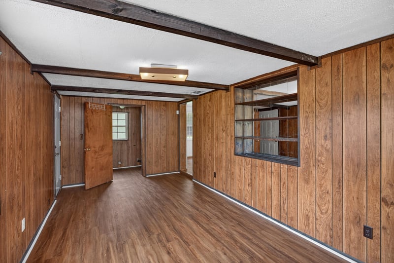 Wood-paneled room with beams and hallway view at 5812 Tampico Rd, Jacksonville, FL 32244