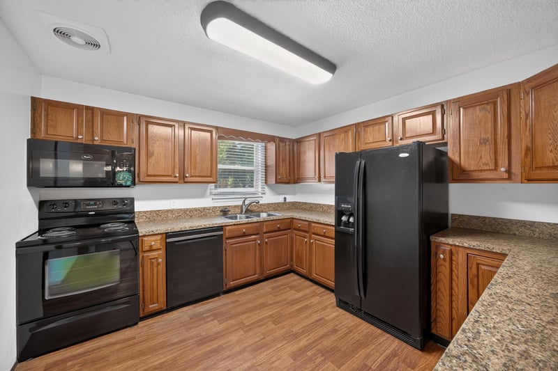 Kitchen with oak cabinets and black appliances at 892 Branscomb Rd, Green Cove Springs, FL