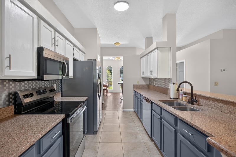 Kitchen with dark cabinets, island, and tile floor at 11828 Heather Grove Ln, Jacksonville, FL