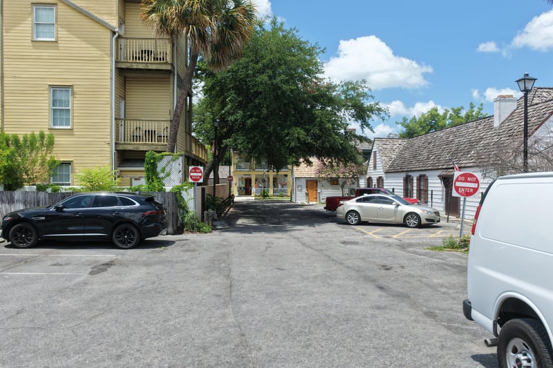 Courtyard view of the yellow building with parked vehicles at 29 Cuna St, St. Augustine, FL 32084