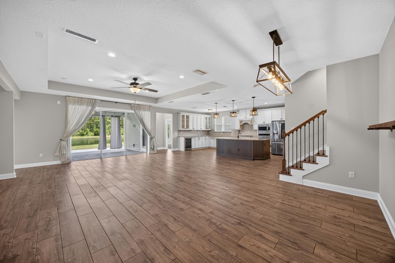 Open great room with wood floors, ceiling fan and staircase at 53 Lumen Ct, St. Augustine, FL 32095