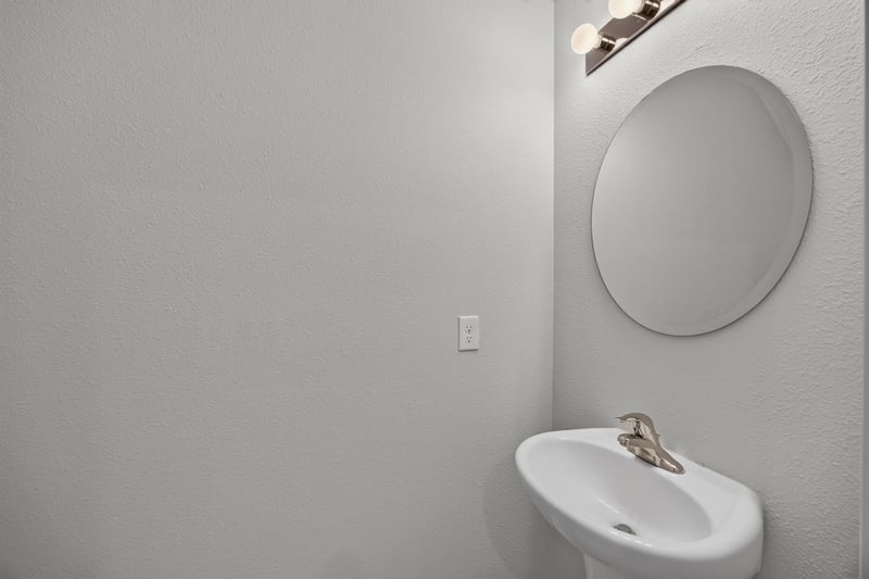 Powder room with pedestal sink and oval mirror at 2837 Black Buck Cir, Jacksonville, FL 32225