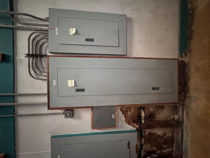 Open electrical panel with conduit and water staining at 11700 New Kings Rd, Jacksonville, FL 32219