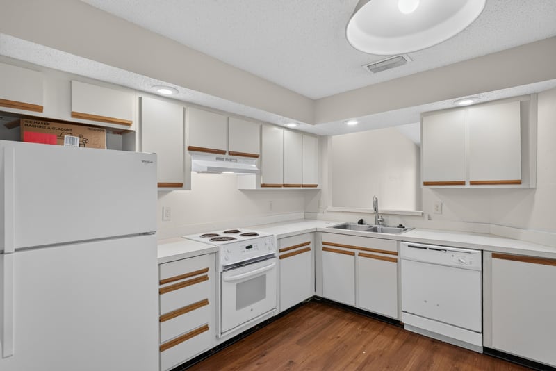 Kitchen with white cabinets and appliances at 8010 International Village Dr, Jacksonville, FL 32277
