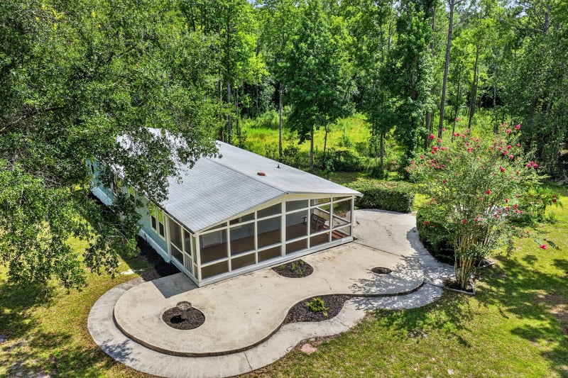 Aerial close view of screened porch and stone patio at 4890 McAllister Rd, Middleburg, FL 32068