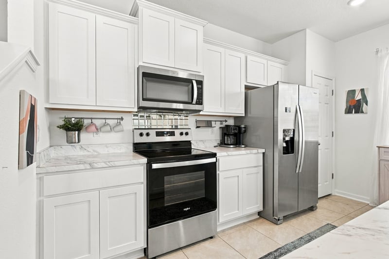 Kitchen cabinetry with microwave and refrigerator at 8359 Zenith Cir, Jacksonville, FL 32256