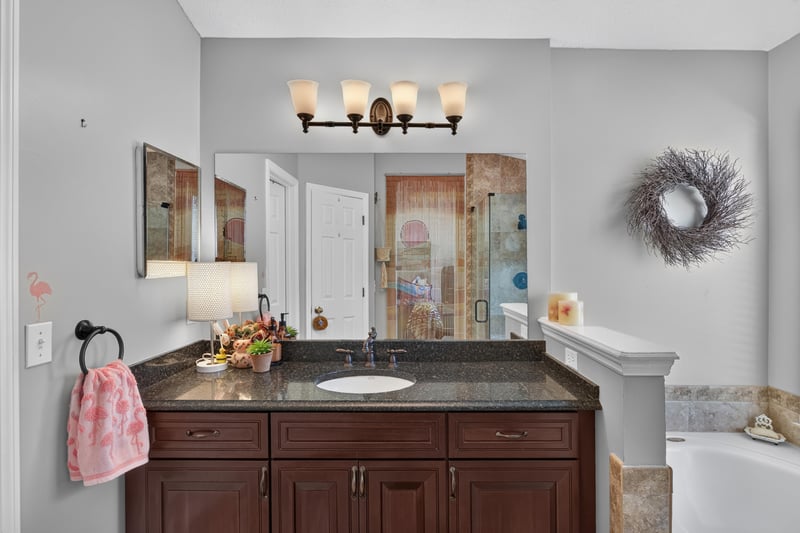 Bathroom vanity with dark wood cabinets and double sinks at 1820 Burgess Hill Dr E, Jacksonville, FL