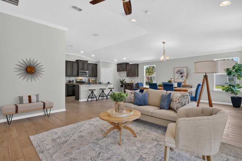 Living room open to the kitchen with gray sofa at 10066 Andean Fox Dr, Jacksonville, FL 32222