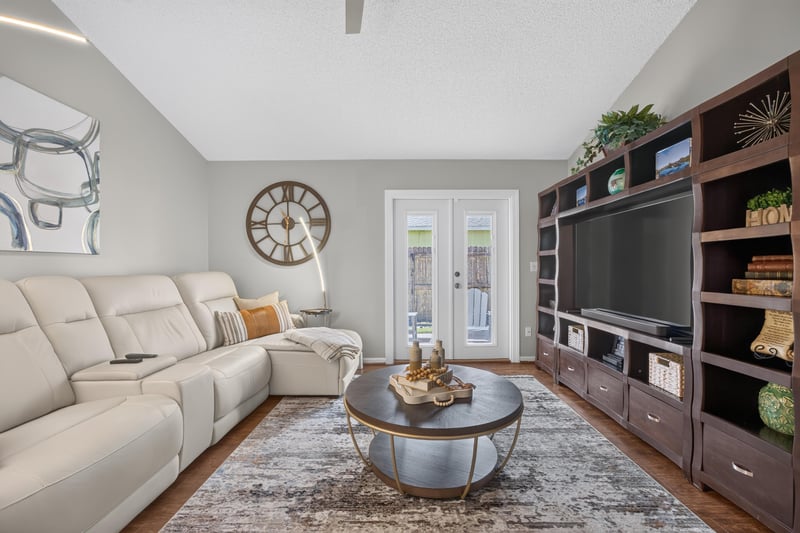 Living room with sectional sofa and built-in shelving at 3067 Wavering Ln, Middleburg, FL 32068