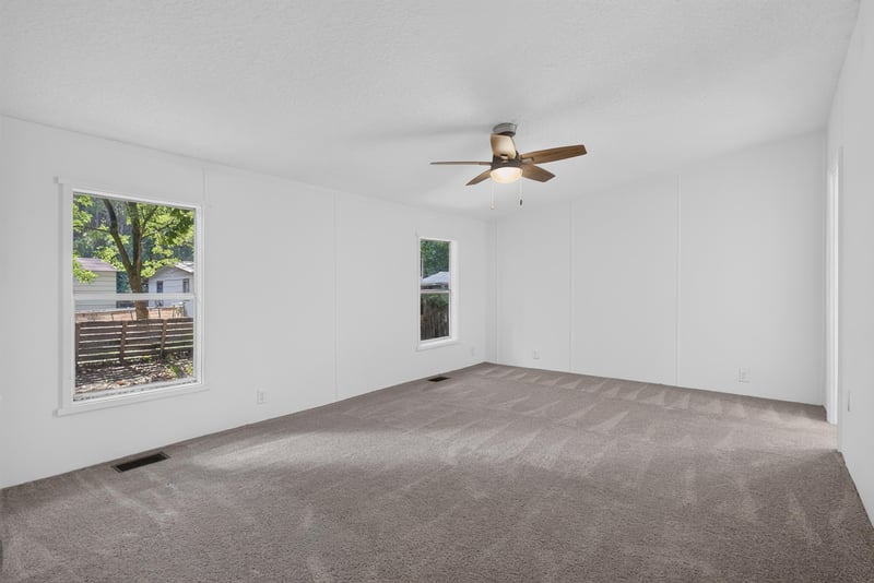 Primary bedroom with windows and ceiling fan at 55520 Jewel-Thomas Rd, Callahan, FL 32011
