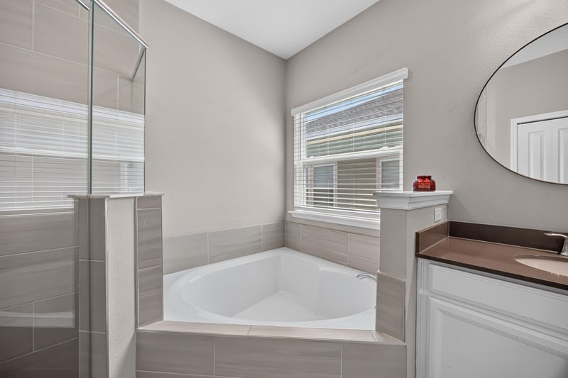 Primary bathroom soaking tub by window at 9942 Lovage Ln, Jacksonville, FL 32219