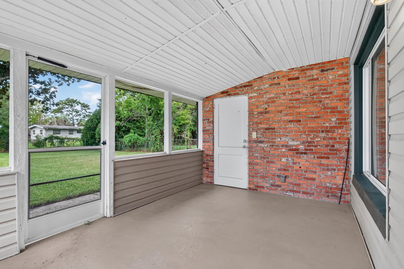 Screened sunroom with brick wall and sliding door at 2618 Arlex Dr E, Jacksonville, FL