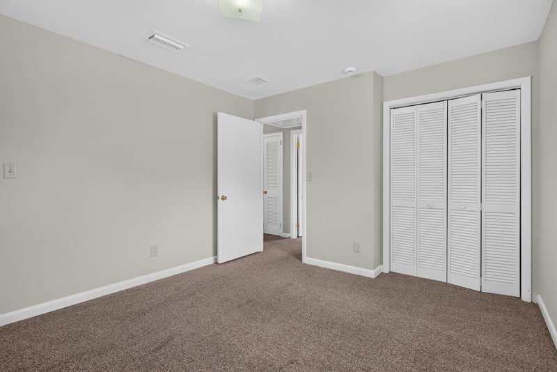 Carpeted bedroom with double closet doors at 2618 Arlex Dr E, Jacksonville, FL
