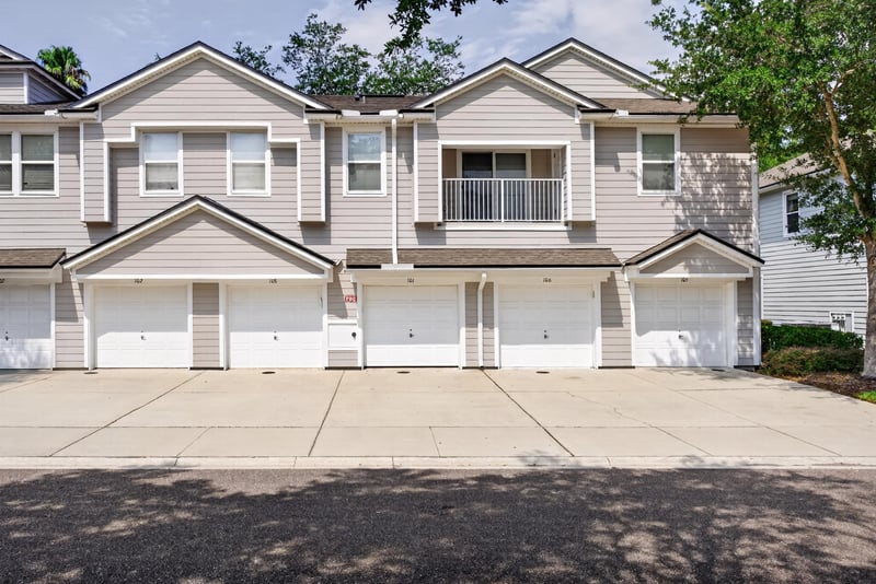 Front exterior of a two-story townhome with attached garages at 8196 Cabin Lake Cir, Jacksonville, FL 32256