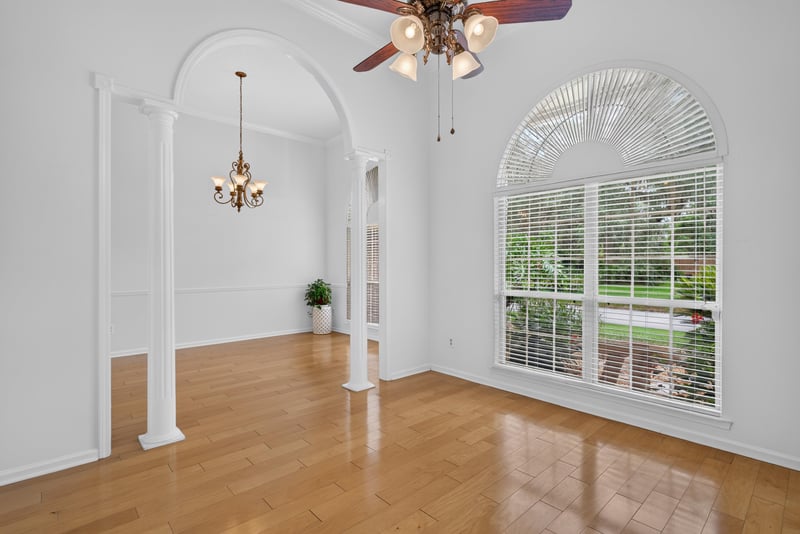Formal living room with arched window and wood floors at 12810 Swamp Owl Ln
