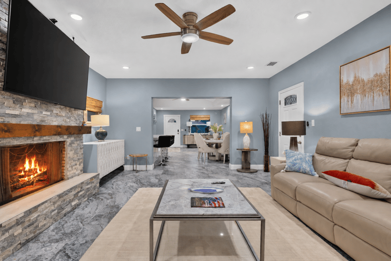Living room with stone fireplace and dining area beyond at 1525 8th St N, Jacksonville Beach, FL
